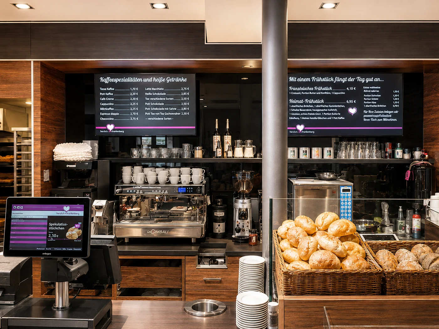 Kassenplatz mit digitaler Bildschirmwerbung im Café-Bereich der Bäckerei Heicks